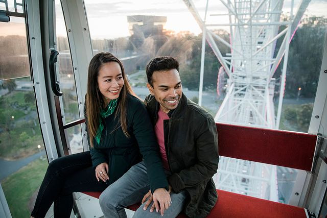 A couple enjoying a Ferris wheel ride dressed in layers.