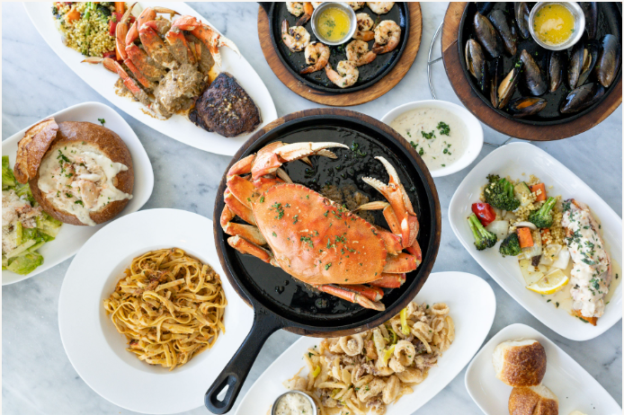 Dungeness crab surrounded by other seafood dishes
