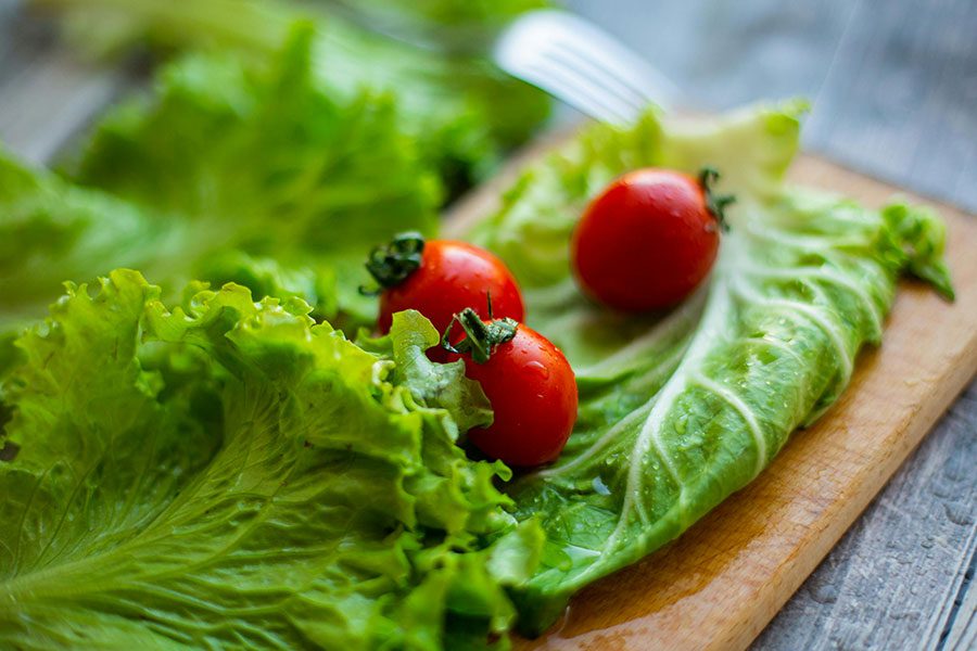 Lettuce and tomatoes placed on chopping board