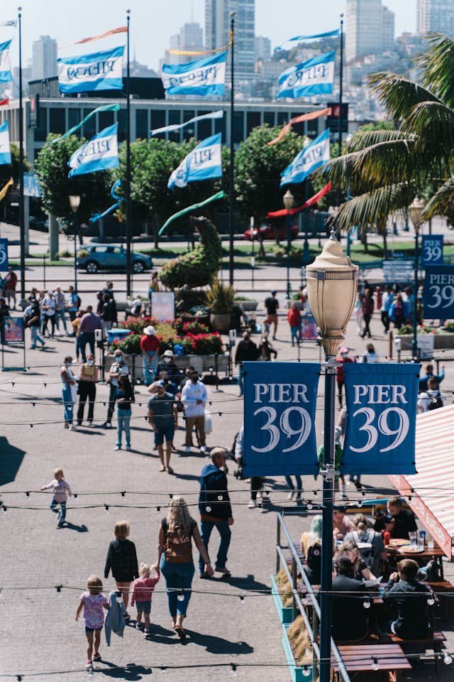 People walking underneath Pier 39 sign